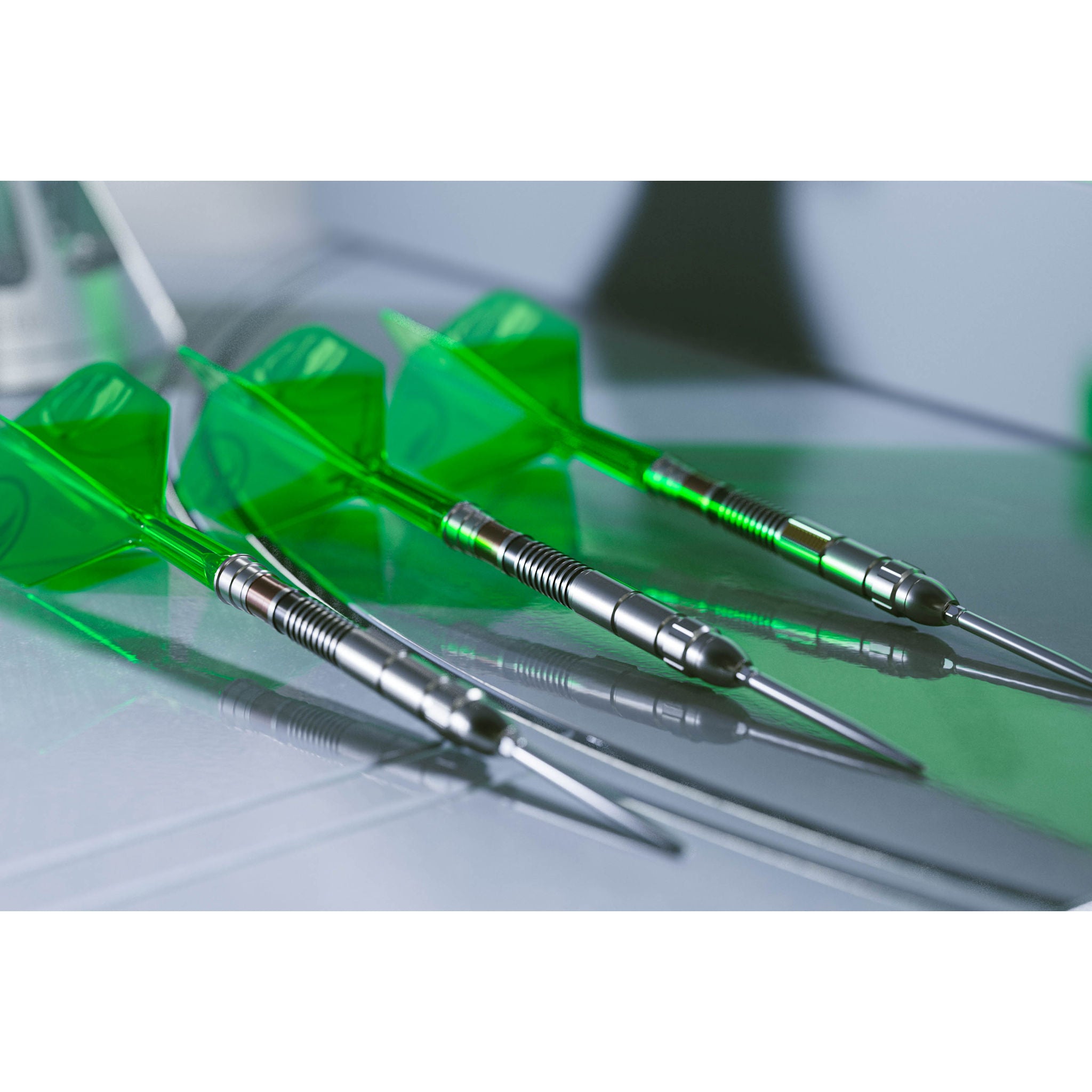 Three green darts with silver shafts on a reflective surface Three green darts with silver shafts on a reflective surface