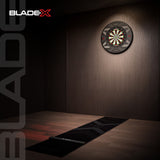 Dartboard on a wooden wall with BladeX branding.