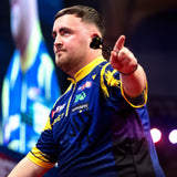 Luke Littler in a purple and yellow sports jersey pointing forward with a blurred background