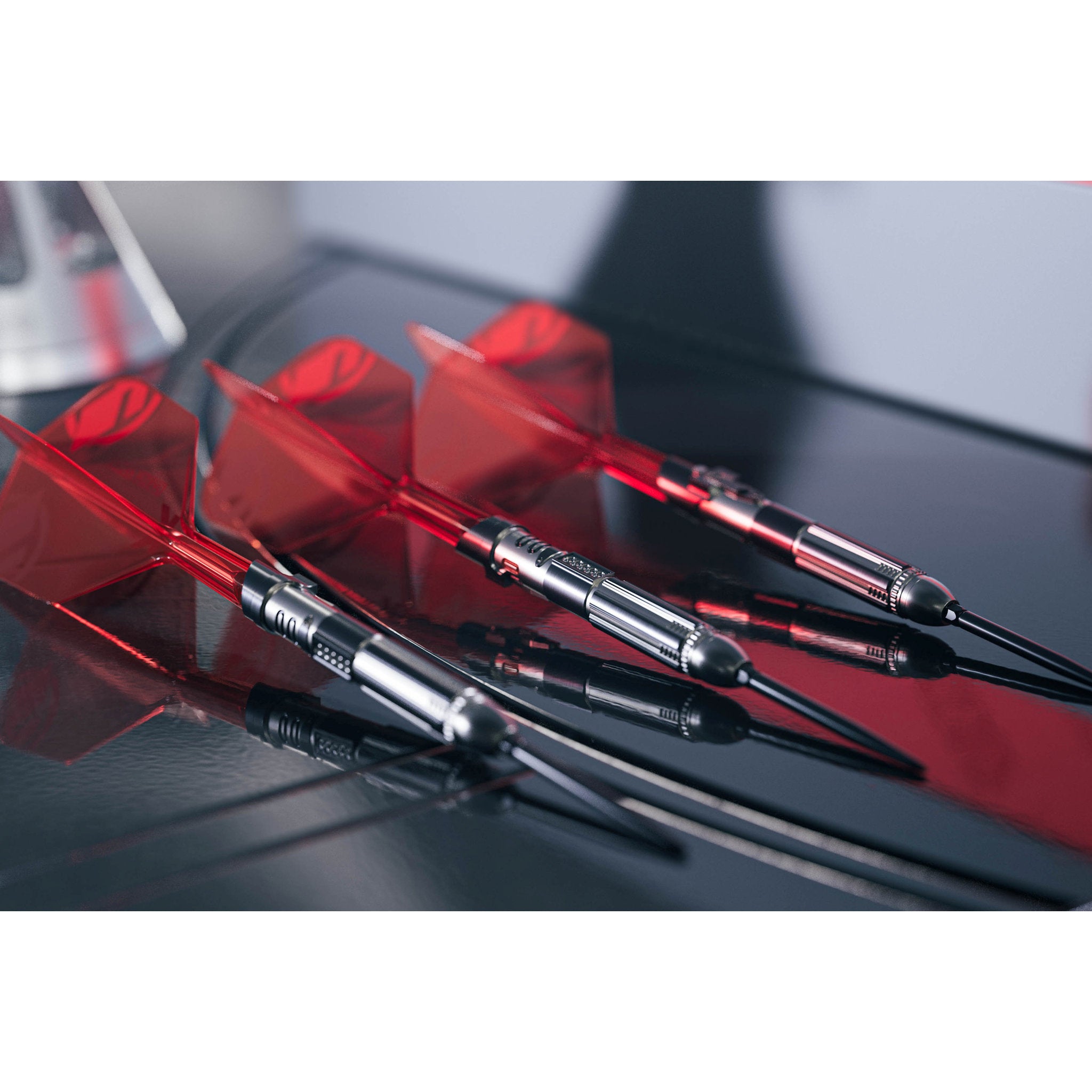 Three darts with red flights on a reflective surface