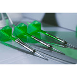 Three green darts with silver shafts on a reflective surface