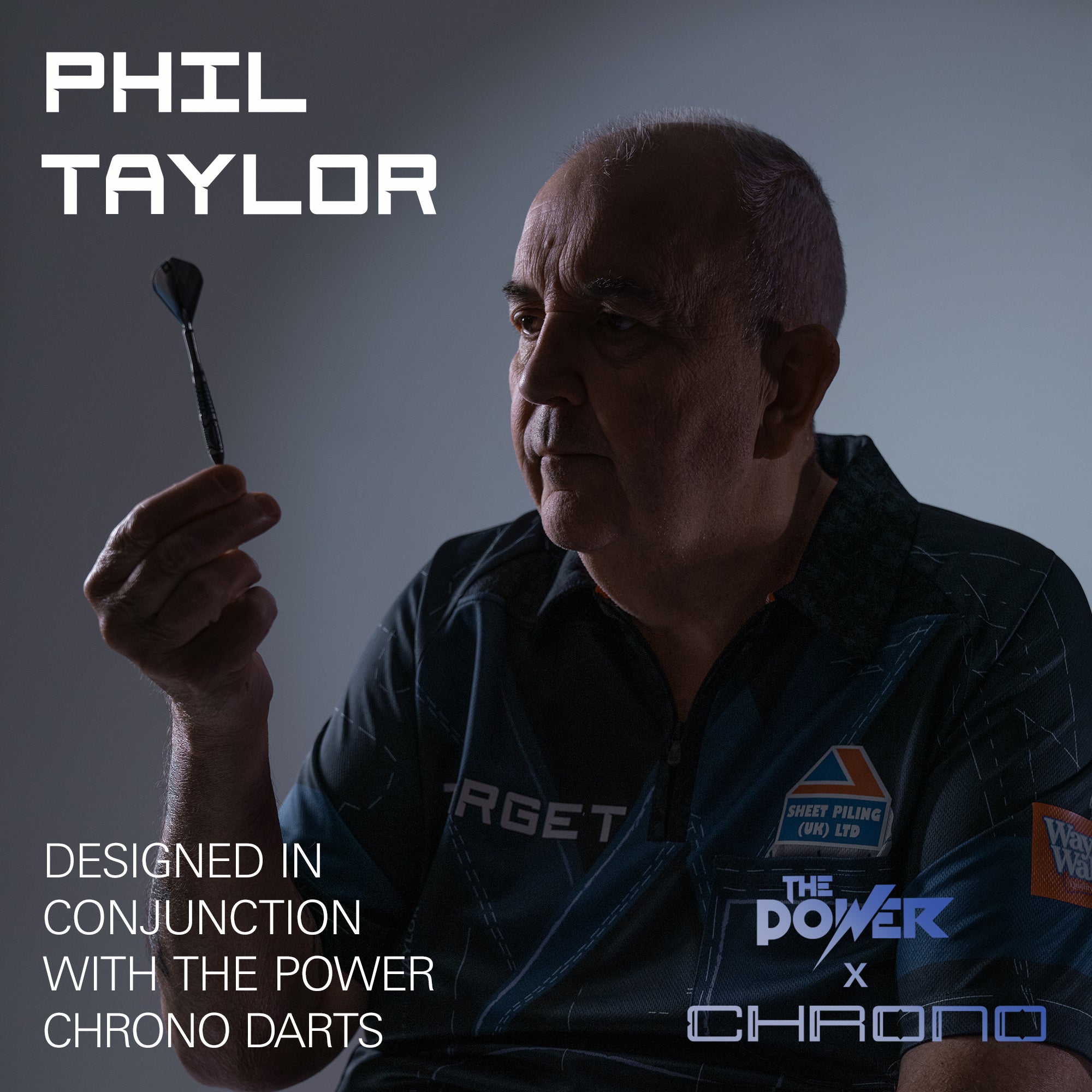 A promotional graphic for a Target darts shirt worn by Phil Taylor, who is holding a dart. The image features text overlays reading 'PHIL TAYLOR' and 'DESIGNED IN CONJUNCTION WITH THE POWER CHRONO DARTS' along with 'THE POWER x CHRONO' branding.