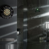 Dartboard on a wall in a modern, dimly lit room with metallic and glass elements.