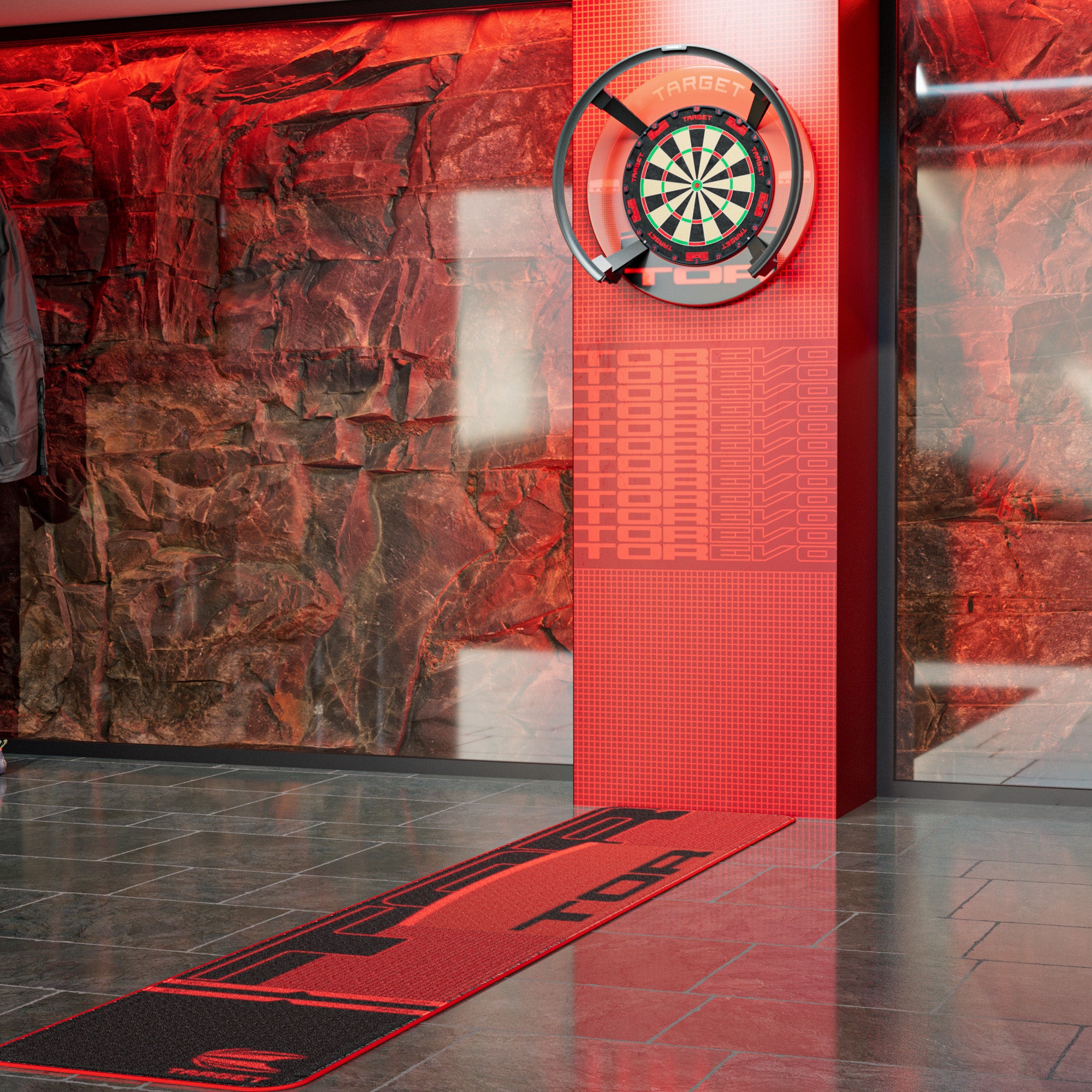 A red and black dartboard mat with the word 'TOR' printed on it, laid out on a gray tiled floor in front of a red LED wall and dartboard in a modern indoor setting.