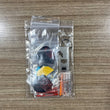 A clear plastic zip-top bag containing a small dart keychain set on a wood-grain tabletop. The set includes assorted dart Accessory Pack.  Side A