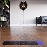 Dartboard with electronic scoring system on a wooden floor in a living  showing the Luke Littler oche room setting.